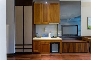 a kitchen with wooden cabinets and a sink at SEEU Designer Apartment - Qiaoxiang Metro, Futian Shenzhen in Shenzhen