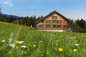 a house on a hill with a field of flowers at Gartenstudio Waldblick in Schwarzenberg