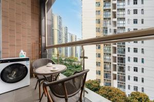a balcony with a table and chairs and a washing machine at SEEU Designer Apartment - Qiaoxiang Metro, Futian Shenzhen in Shenzhen