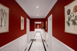 a hallway with red walls and a white tile floor at Hotel Stadtresidenz in Hildesheim