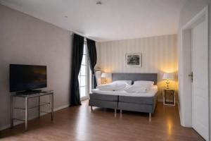 a bedroom with a bed and a flat screen tv at Hotel Stadtresidenz in Hildesheim +54 photos