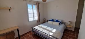 a bedroom with a bed with blue pillows and a window at Hôtel restaurant ANGEL'S in Angles