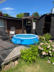 a blue tub in a yard with some flowers at Atpūtas vieta ar pirti, with wi-fi, self check in and private parking in Ventspils