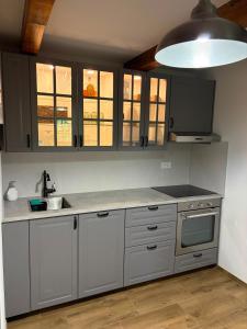 a kitchen with gray cabinets and a sink at Chalet Le Klet in Krapinske Toplice
