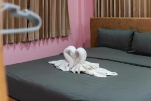 a bed with two swan towels on it at PoonsukPlace Sampran in Ban Bang Yai Chuai