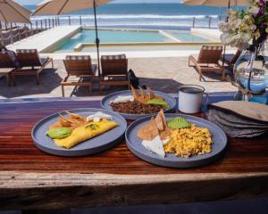 three plates of food on a table near a pool at Hotel Calma Celesti in Perihuete