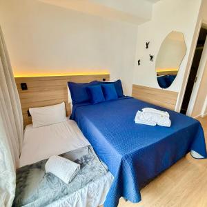 a bedroom with a blue and white bed next to a bedskirts at Blue Apto Automatizado Moderno in São Paulo