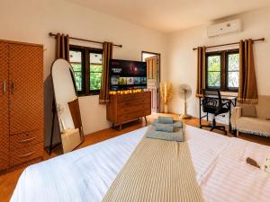 a bedroom with a large bed and a television at Charming House - Peaceful Garden Retreat - 2mn ZenBeach - Srithanu Center in Srithanu