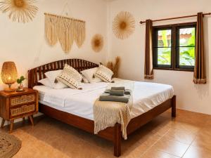 a bedroom with a bed and a table and a window at Charming House - Peaceful Garden Retreat - 2mn ZenBeach - Srithanu Center in Srithanu