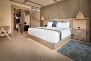a bedroom with a large white bed in a room at Hotel Indigo Playa del Carmen by IHG in Playa del Carmen