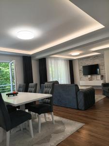 a living room with a couch and a table and chairs at Villa Balic Sarajevo in Sarajevo