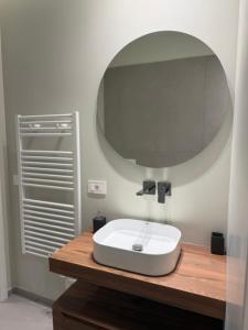 a bathroom with a white sink and a mirror at Rooms Residence Rubiera in Rubiera +18 photos