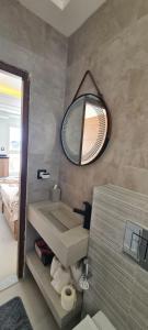 a bathroom with a sink and a mirror on the wall at Dar Lebharr Studio in Kelibia +26 photos
