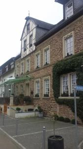 un bâtiment en briques avec un panneau de rue devant lui dans l'établissement Landgasthaus am Ufer, à Traben-Trarbach