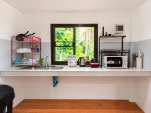 a kitchen counter with a microwave and a window at Charming House - Peaceful Garden Retreat - 2mn ZenBeach - Srithanu Center in Srithanu
