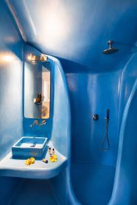 a blue bathroom with a sink and a mirror at La Bellezza Eco Boutique Hotel in Kamari +31 photos