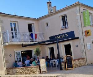 a group of people sitting outside of a restaurant at Hôtel restaurant ANGEL'S in Angles