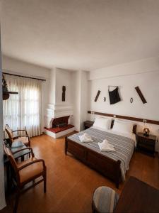 a bedroom with a large bed and a fireplace at Sintrivanis Mountain in Áno Skotína