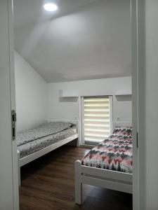 a bedroom with two beds and a window at Villa Balic Sarajevo in Sarajevo