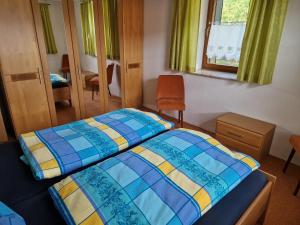 a bedroom with two beds and a chair and a window at Ferienwohnung am Chemnitztalradweg in Taura
