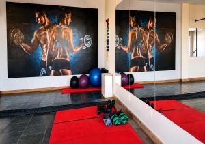 a gym with a red carpet and a wall with posters at Flat Serra negra prox ao Centro lazer completo in Serra Negra