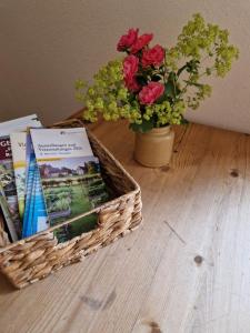 a basket of books and a vase with flowers at Ferienwohnung am Chemnitztalradweg in Taura