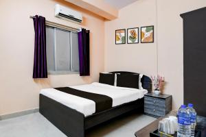 a bedroom with a black and white bed and a window at HOTEL O THE INFINITY in Jādabpur