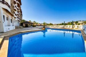a large swimming pool next to a building at Flat Serra negra prox ao Centro lazer completo in Serra Negra