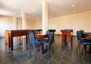 a room with tables and chairs and a piano at Flat Serra negra prox ao Centro lazer completo in Serra Negra
