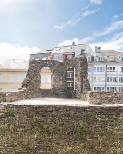 an old stone wall with buildings in the background at Hostal ALBA Lugo in Lugo