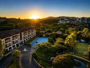 an aerial view of a building with a pool and palm trees at Flat Serra negra prox ao Centro lazer completo in Serra Negra