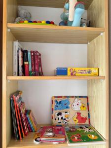a wooden book shelf with books and toys on it at Le Panorama de Valberg in Valberg