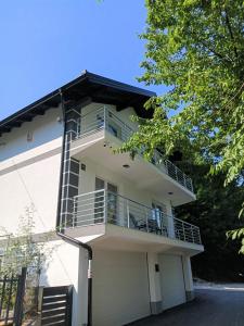 a white building with a balcony on it at Villa Balic Sarajevo in Sarajevo