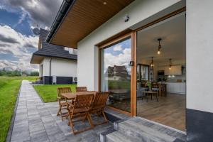 a patio with a table and chairs and a kitchen at Czarna Owca in Biały Dunajec