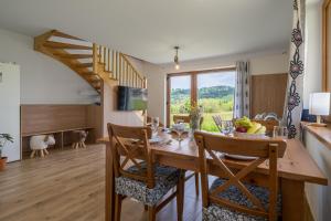 a kitchen and dining room with a wooden table and chairs at Czarna Owca in Biały Dunajec