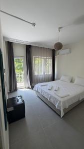 ein Schlafzimmer mit einem großen weißen Bett und Fenstern in der Unterkunft Corte Hotel Kaş in Kaş