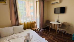 a hotel room with a bed and a table with chairs at AMADEUS I Studio 25 Sunny Beach in Sunny Beach