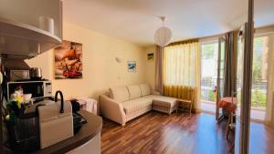 a living room with a couch and a table at AMADEUS I Studio 25 Sunny Beach in Sunny Beach