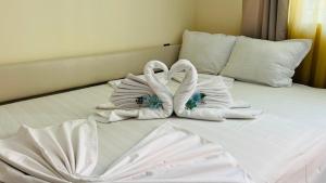 two swans folded towels sitting on a bed at AMADEUS I Studio 25 Sunny Beach in Sunny Beach +22 photos