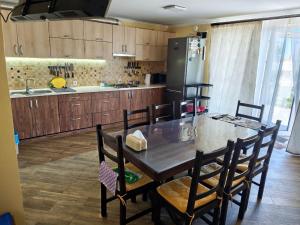 a kitchen with a table and chairs and a refrigerator at Гостинний дім "Алмаз" in Kurortne