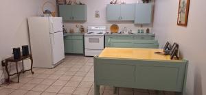 a kitchen with green cabinets and a white refrigerator at The Cabin at Solitude Junction in Opdyke