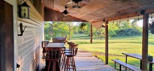 a covered porch with a grill and stools on it at The Cabin at Solitude Junction in Opdyke +10 photos