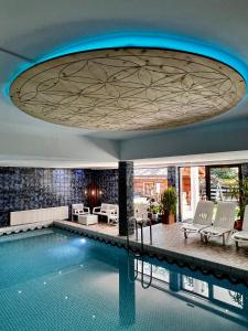 a pool in a hotel with a large ceiling at Hotel Garni Obermair in Mayrhofen