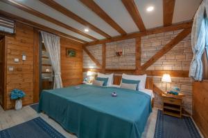 a bedroom with a bed in a room with wooden walls at Plitvice Lakes Hotel Ethno Houses in Plitvička Jezera