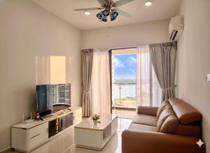 a living room with a couch and a large window at Amberside Coastal Breeze Oasis in Johor Bahru