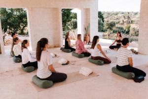 a group of people sitting in a yoga class at Trulli Lumena in Ostuni