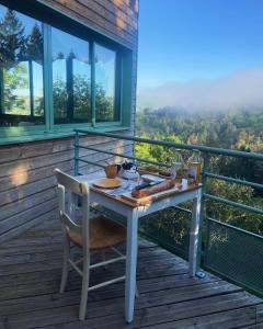 a table and chair on a balcony with a view at Auberge du Fel in Le Fel