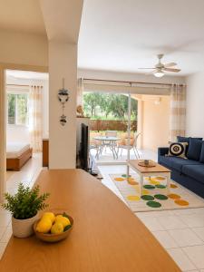 a living room with a table and a blue couch at Athena Apartment in Polis Chrysochous