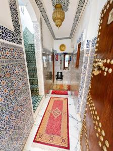 a hallway with a persian rug in a mosque at Riad Dar El Kaid in Fez