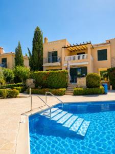 a swimming pool in front of a house at Athena Apartment in Polis Chrysochous